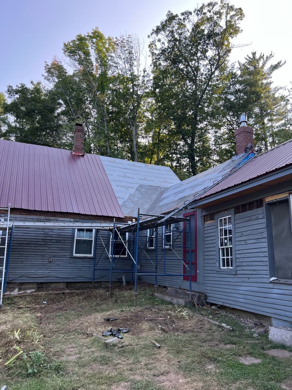 A red metal roof partially complete during installation