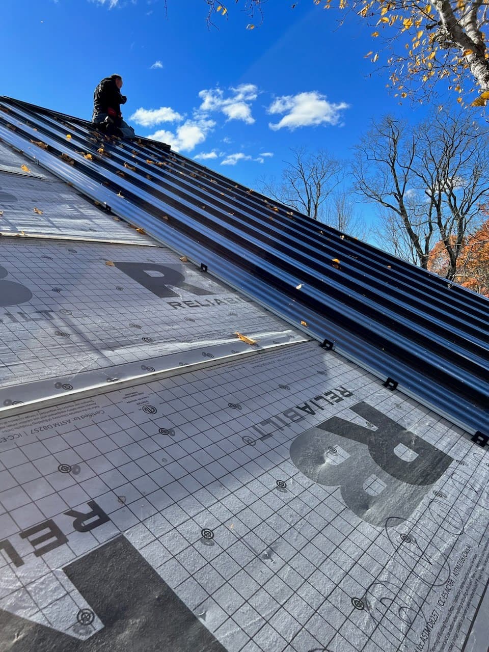 A standing seam metal roof partially complete